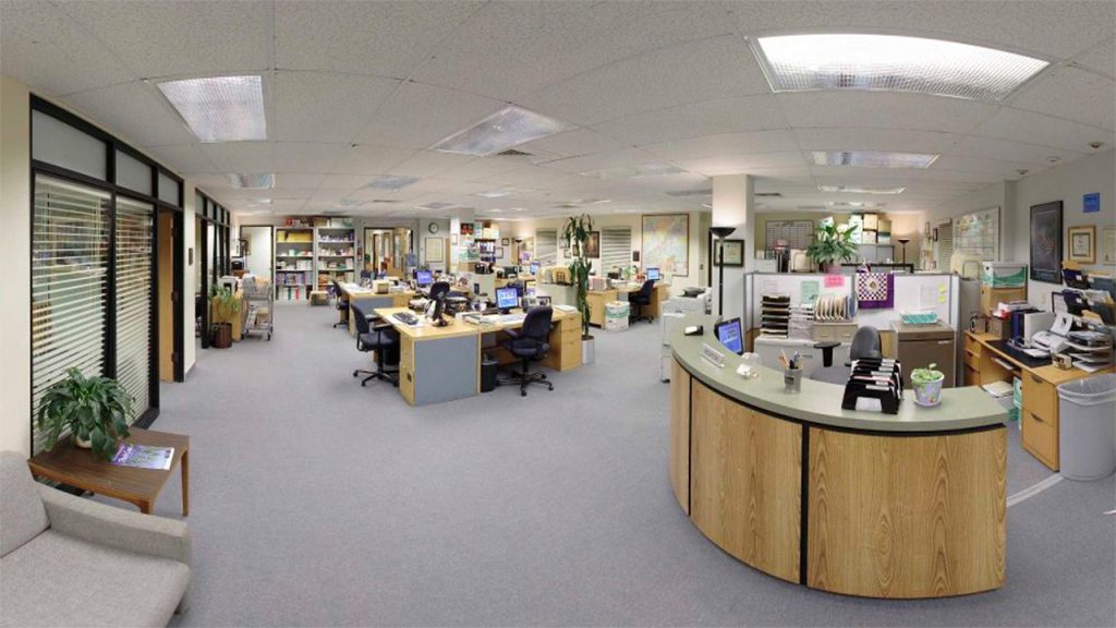 Wide view of Dunder Mifflin's Scranton office with desks and staff workspace.